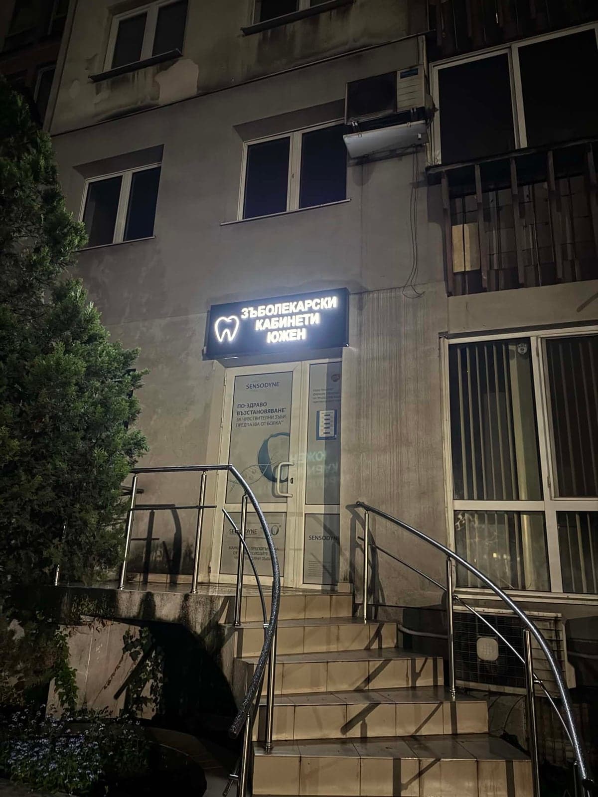 Входът на T&Co Dental на ул. „Даме Груев“ 34 вечер: стълбище с парапет и светеща табела